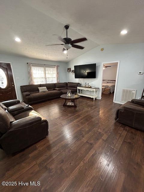 living area featuring visible vents, wood-type flooring, a ceiling fan, and vaulted ceiling