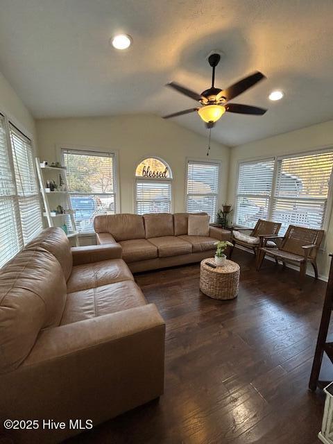 living room featuring a wealth of natural light, a ceiling fan, dark wood-type flooring, and lofted ceiling