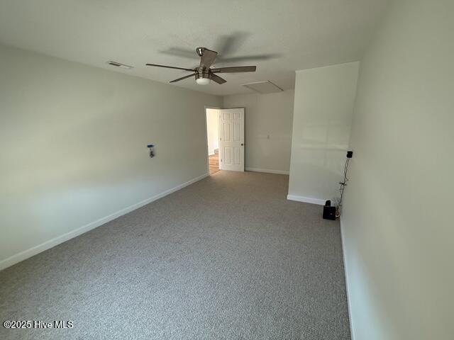 empty room with visible vents, ceiling fan, and baseboards