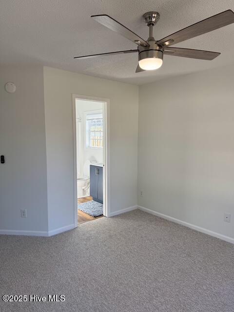 unfurnished room with light carpet, baseboards, a textured ceiling, and a ceiling fan