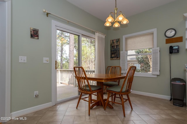 dining space featuring a notable chandelier, a healthy amount of sunlight, and baseboards