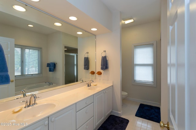 full bath with double vanity, recessed lighting, a stall shower, and a sink