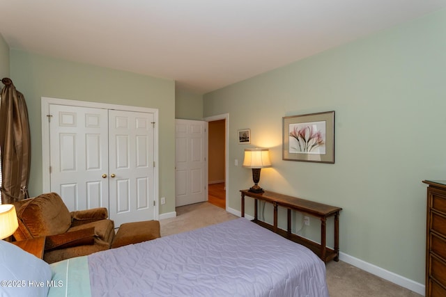 bedroom featuring a closet, light colored carpet, and baseboards