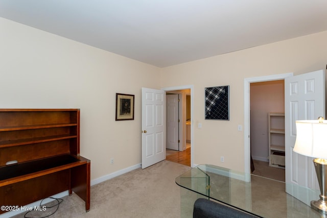 carpeted home office featuring baseboards