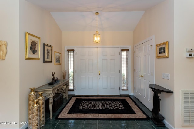 foyer with visible vents, a healthy amount of sunlight, baseboards, and dark tile patterned flooring