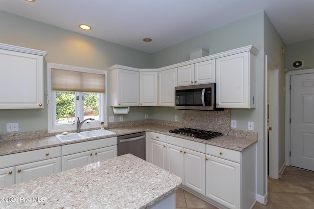 kitchen featuring white cabinetry, light tile patterned flooring, appliances with stainless steel finishes, and a sink