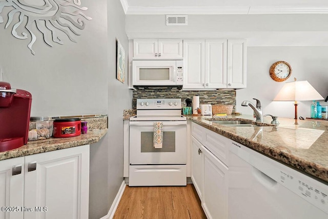 kitchen with tasteful backsplash, visible vents, ornamental molding, white appliances, and a sink