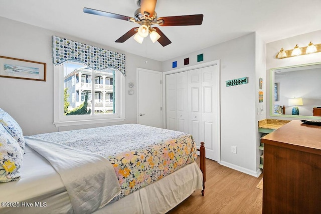 bedroom with light wood-type flooring, baseboards, a closet, and ceiling fan