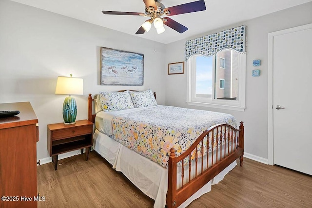 bedroom featuring ceiling fan, baseboards, and wood finished floors