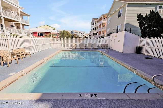 pool with a residential view, a patio, and a fenced backyard