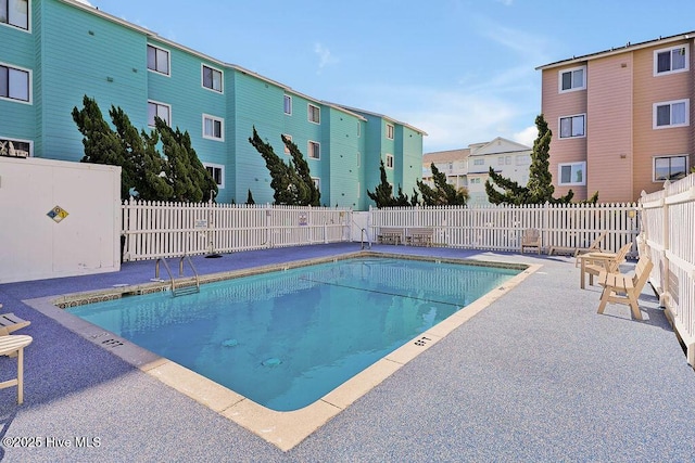 community pool featuring a patio and a fenced backyard