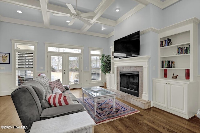 living area featuring beamed ceiling, wood finished floors, and french doors