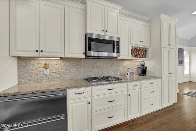 kitchen featuring decorative backsplash, dark wood-type flooring, light stone countertops, and stainless steel appliances