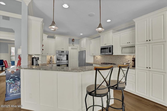 kitchen featuring tasteful backsplash, dark wood-style floors, stainless steel appliances, a peninsula, and crown molding