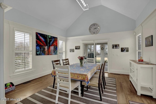 dining area featuring visible vents, high vaulted ceiling, baseboards, and wood finished floors