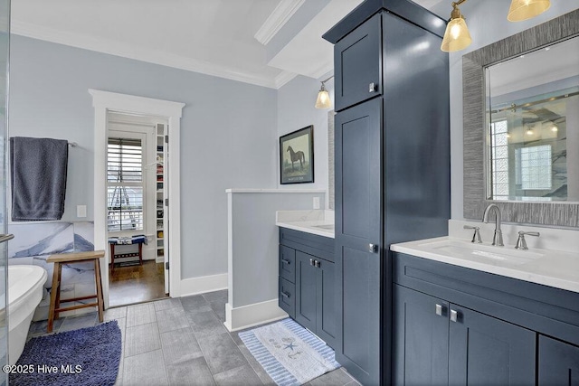 full bathroom with baseboards, a soaking tub, two vanities, ornamental molding, and a sink