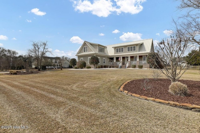 view of front of house featuring a porch, metal roof, and a front yard