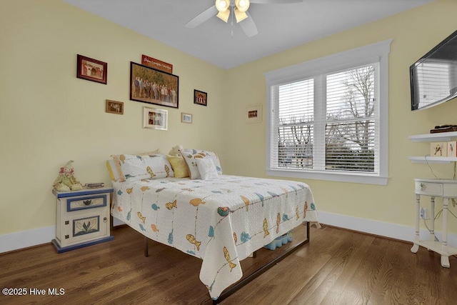 bedroom featuring dark wood-style floors, a ceiling fan, and baseboards