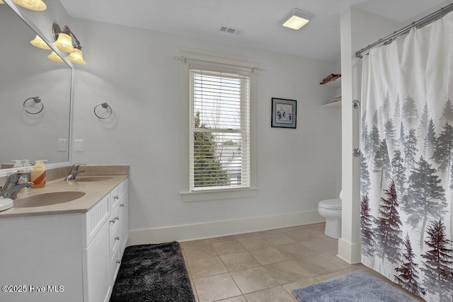 bathroom with tile patterned flooring, double vanity, visible vents, and a sink