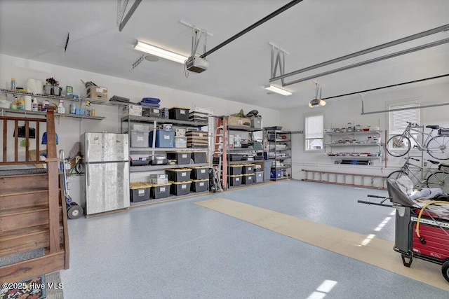 garage with freestanding refrigerator and a garage door opener