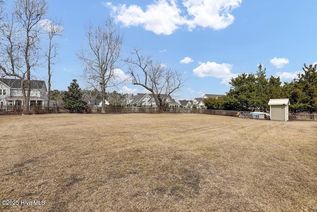 view of yard with a storage shed, an outdoor structure, and fence