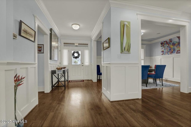 entrance foyer featuring a decorative wall, ornamental molding, and dark wood-style flooring