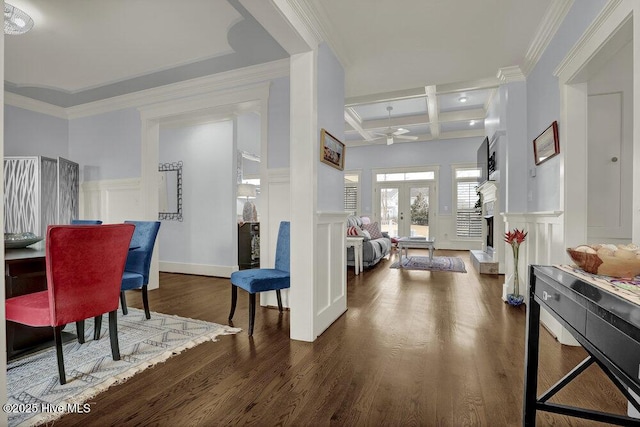 foyer with beamed ceiling, coffered ceiling, wood finished floors, a decorative wall, and ceiling fan