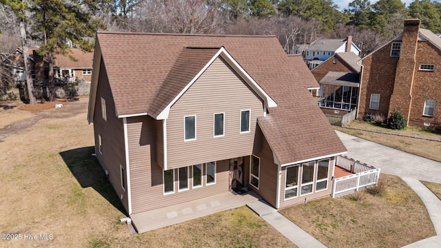 view of front facade featuring a front lawn and a shingled roof