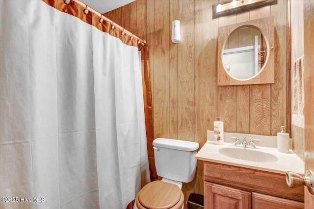 full bath with curtained shower, wooden walls, toilet, and vanity