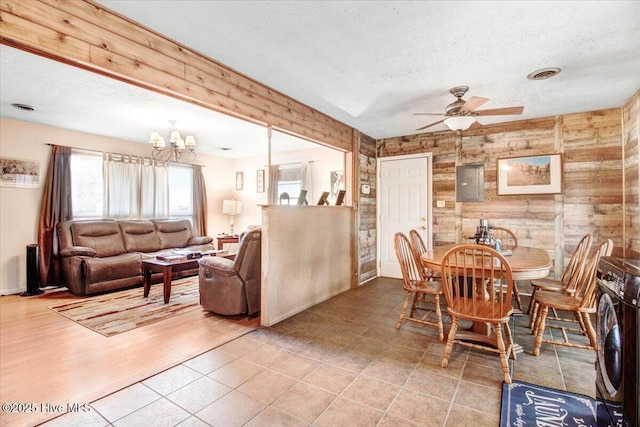 dining area featuring washer / dryer, ceiling fan with notable chandelier, visible vents, and a textured ceiling