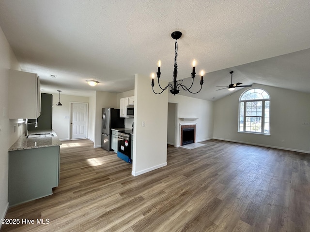 kitchen featuring white cabinets, wood finished floors, appliances with stainless steel finishes, and a sink