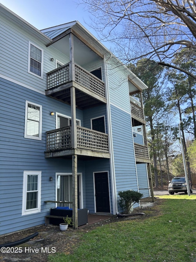 rear view of property featuring a lawn