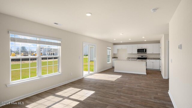 unfurnished living room with dark wood-style floors, recessed lighting, baseboards, and visible vents