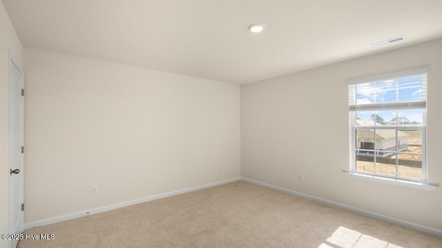 empty room featuring baseboards, visible vents, and carpet floors