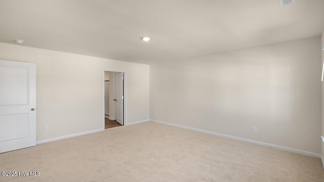 spare room with recessed lighting, baseboards, and light carpet