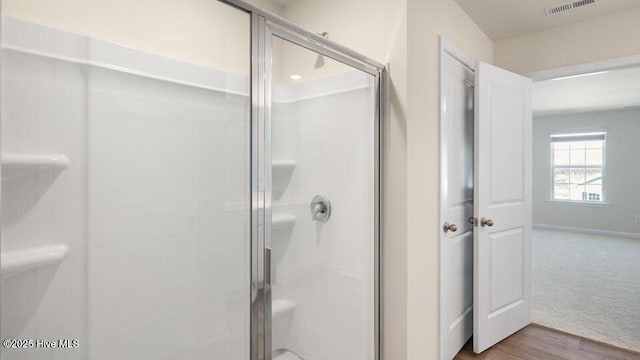 bathroom featuring wood finished floors, visible vents, a stall shower, and baseboards