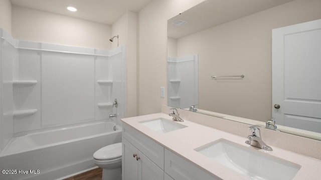 bathroom with toilet, washtub / shower combination, and a sink