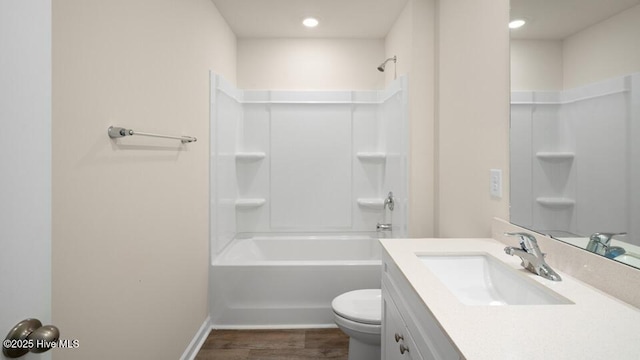 bathroom featuring baseboards, toilet, shower / bath combination, wood finished floors, and vanity