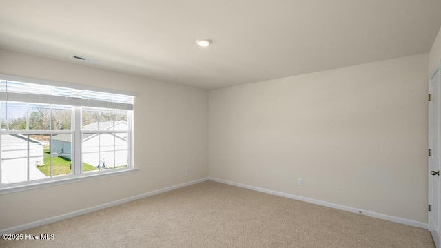 unfurnished room with light colored carpet and baseboards