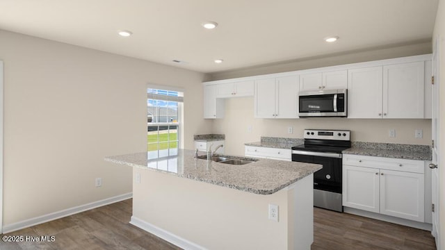 kitchen featuring a sink, appliances with stainless steel finishes, dark wood-style floors, white cabinets, and a kitchen island with sink