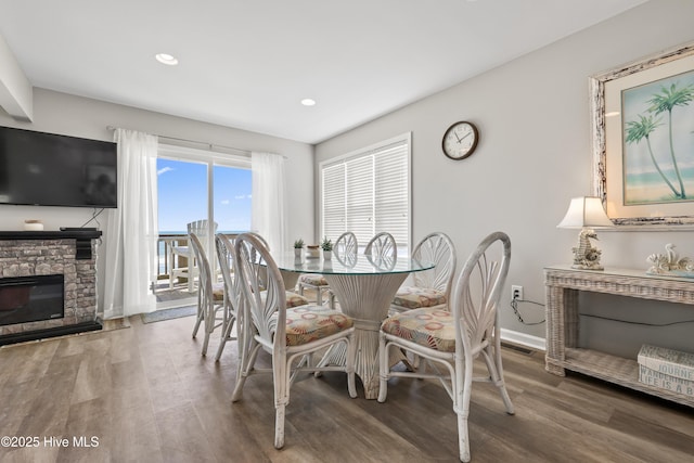 dining area with visible vents, baseboards, recessed lighting, a fireplace, and wood finished floors