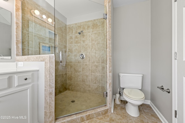 full bath with tile patterned floors, toilet, a stall shower, baseboards, and vanity