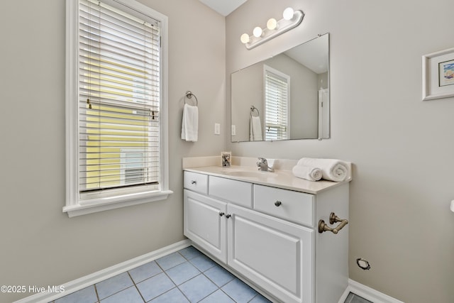 bathroom with baseboards, vanity, and tile patterned flooring