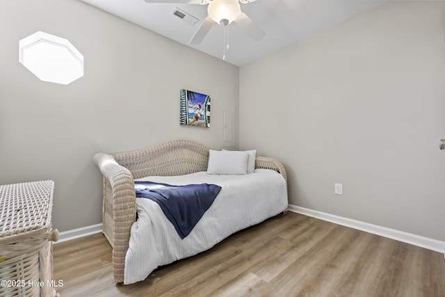 bedroom featuring visible vents, baseboards, wood finished floors, and a ceiling fan