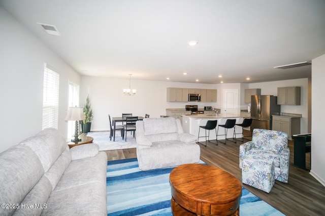 living area featuring an inviting chandelier, dark wood-type flooring, visible vents, and recessed lighting