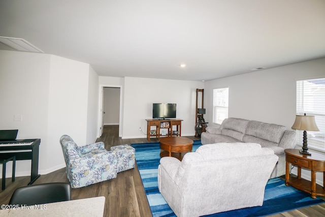 living room with a wealth of natural light, baseboards, and wood finished floors