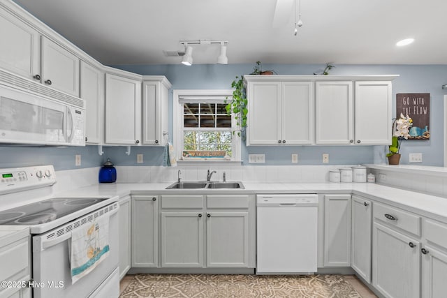 kitchen with light countertops, visible vents, white cabinets, white appliances, and a sink