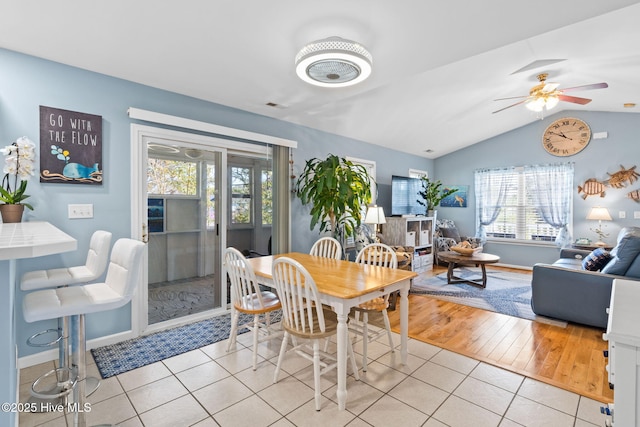dining space featuring ceiling fan, visible vents, vaulted ceiling, and light tile patterned floors