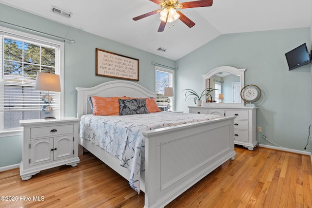 bedroom featuring light wood-style floors, baseboards, lofted ceiling, and visible vents