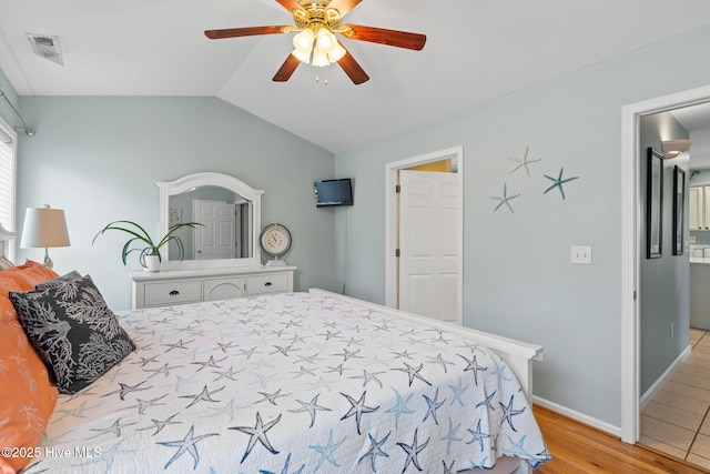 bedroom with vaulted ceiling, a ceiling fan, light wood finished floors, baseboards, and visible vents